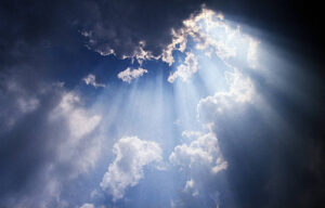 Shafts of sun ray light breaking through cumulus cloud